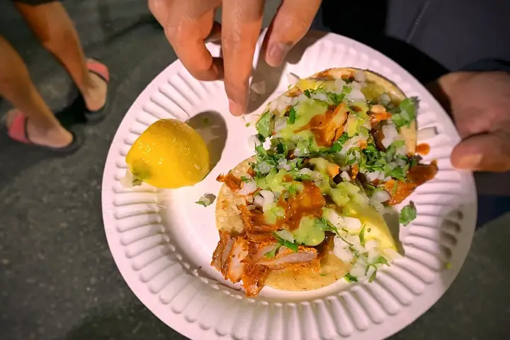 Tacos al pastor servidos con piña y cilantro